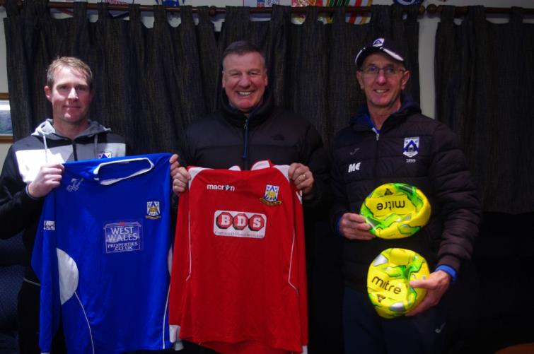 Bernie Armstrong (centre) receives football fit and balls from Haverfordwest County coaches Steve Batty (left) and Micky Ellis (right).