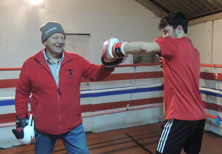 Rowland gives young boxer Joseph Felice some training on the pads