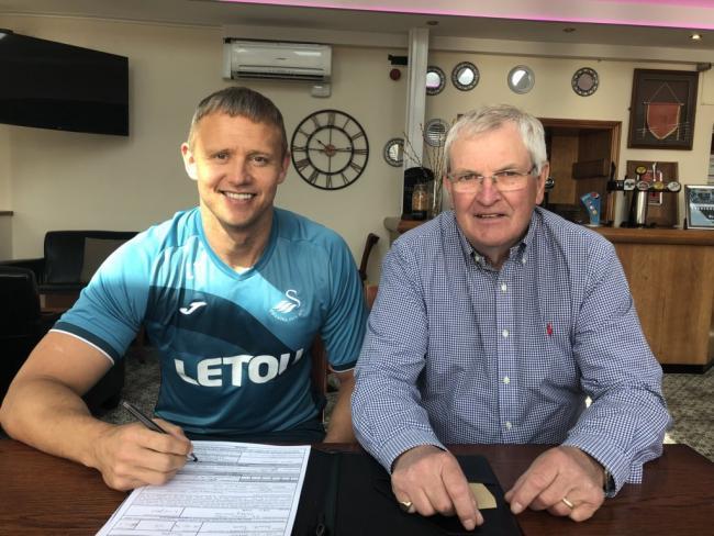 Lee Trundle signs on the dotted line with Haverfordwest County Chairman David Hughes in attendance.